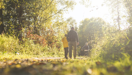 Family walking in the forest. Father and sons hiking in September