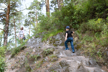 Fototapeta premium Little boy walking with parent in the mountains
