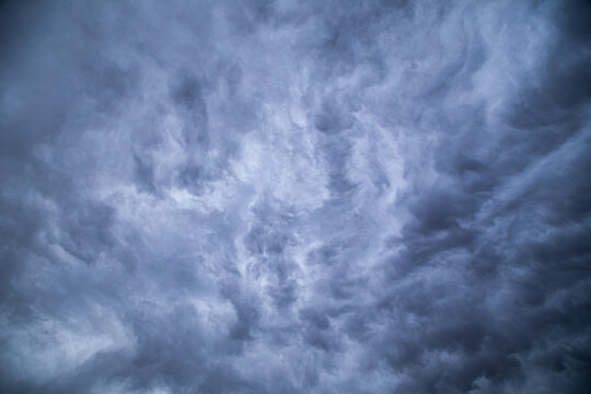 An image of swirling, dark, moody, dramatic storm clouds bringing rain and thunder. 