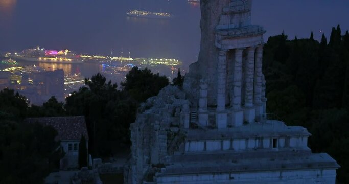 Aerial Forward Beautiful View Of Trophy Of Augustus On Mountain At Night - Monaco