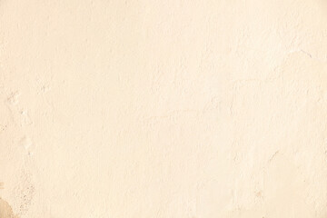 Fototapeta premium Old beige color paint faded wall texture background. Peeled house facade, front view