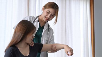 Fototapeta premium Smiling female physiotherapist working with patient in clinic. Physical therapy concept.
