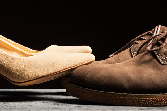 Women's shoes stand on top of men's shoes. The concept of feminization in social and family life.