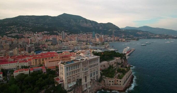 Aerial Shot Of Musee Oceanographique De Monaco In City, Drone Flying Forward Over Nautical Vessels At Harbor In Sea