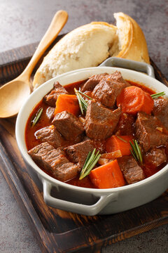 Daube Provencal French braised beef red wine, and vegetable stew closeup in the wooden tray on the table. Vertical