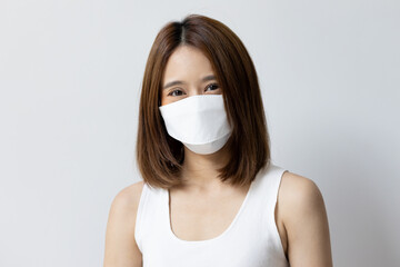 Happy woman wearing white face mask for seasonal flu and dust pollution protection
