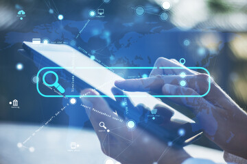 Close up of hand using smartphone with creative search bar and digital blue map icons on blurry...