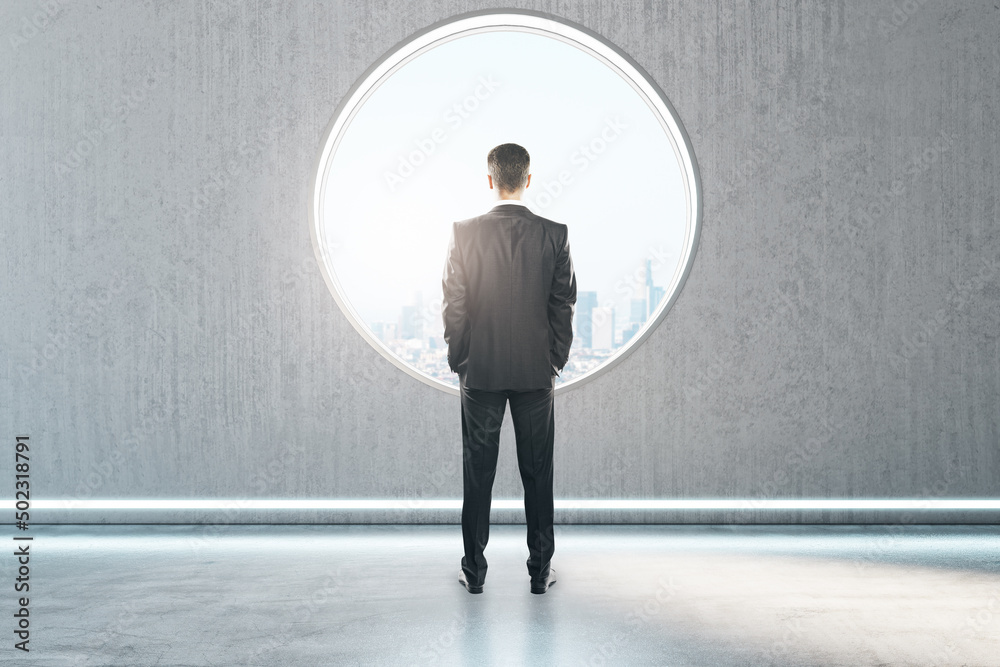 Aufkleber back view of thoughtful young businessman standing in creative modern concrete interior with round w
