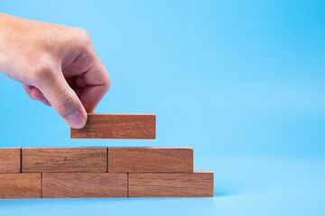 Hand of man piling up and stacking a wooden block. Plan and strategy in business, Risk To Make Business Growth Concept