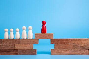  Wooden people figures on top of wooden blocks. Career growth, development and leadership