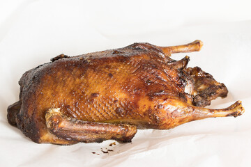 Duck baked until golden brown lies on a light background