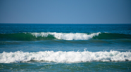 Panorama of ocean waves on a tropical sea with deep blue wawes. Calm sea water, ocean background. Panoramic landscape.