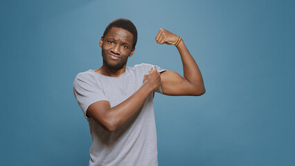 Athletic person flexing biceps and triceps muscles on camera, showing muscular fitness and masculinity. Young fit man expressing endurance and bodybuilding technique. Powerful sportsman.