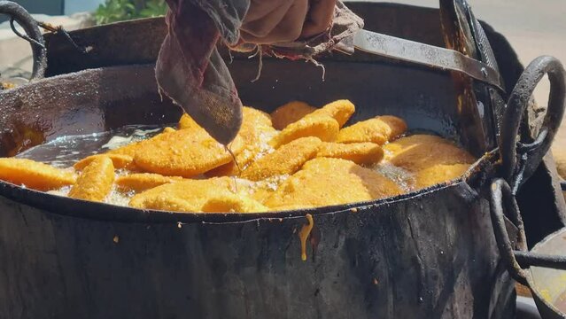 close up of shop cook deep frying many kachori in boiling oil making streetfood snack that is popular throughout rajasthan jaipur India for it's spicy flavor
