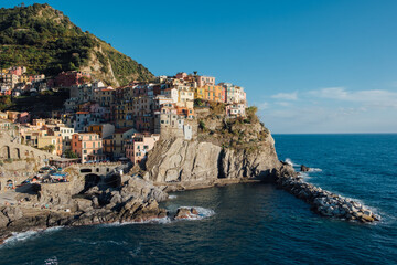 Fototapeta na wymiar Beautiful view of rocky hills and colorful historic buildings of Manarola, tourist attraction and famous place in Liguria, Italy.
