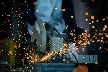Close-up detail of construction engineer workers cutting rebar and reinforcement at a construction site Metal cutting workers sparks while grinding steel Cut the steel bar with a power tool. - obrazy, fototapety, plakaty