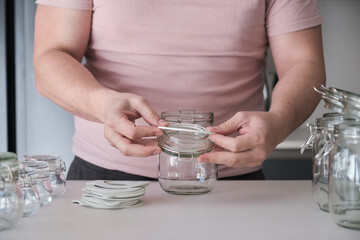 Unrecognizable man putting the rubber seal on a jar cap. Preserving jar.