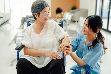 Obraz premium Asian nurse taking care and talking mature female patient sitting on wheelchair in hospital. Healthcare concept.