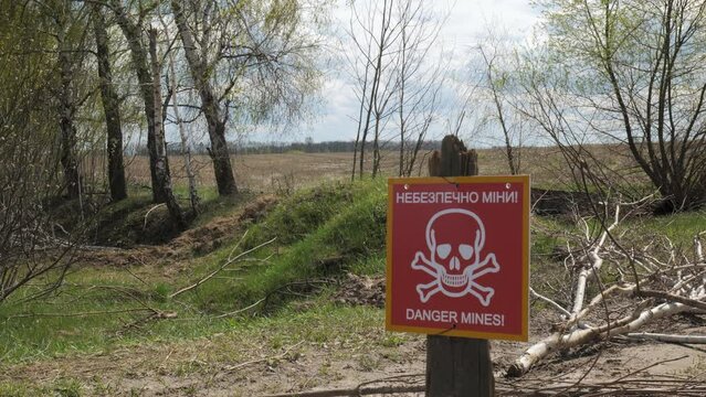 A sign with an inscription in Ukrainian and English Danger of mines