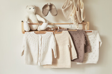 Children's knitted clothes on hanger. Jacket, jumper, hat, shoes. toys. Children's room, nursery