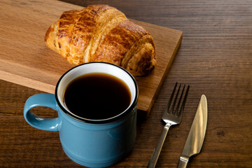 Croissant with a cup of full coffee,directly above	