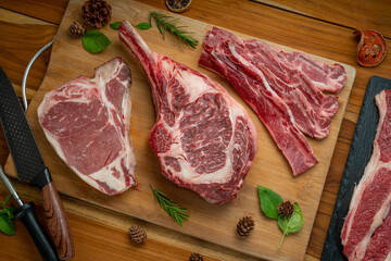 Mixed fresh meat Tomahawk beef, Cross Cut Short Ribs beef, Sliced brisket beef, T-bone steak beef on wooden background.