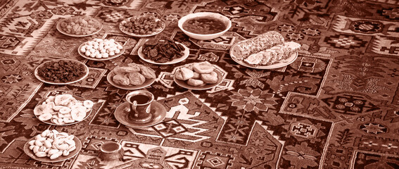 Eastern feast. Asian still life of dried fruits and nuts in plates on a carpet