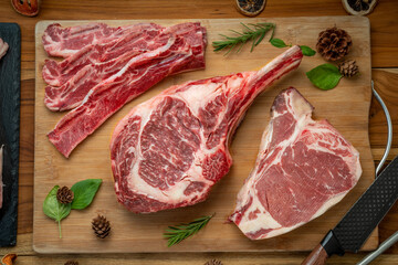 Mixed fresh meat Tomahawk beef, Cross Cut Short Ribs beef, Sliced brisket beef, T-bone steak beef on wooden background.