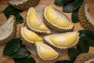Fresh Durian fruit on black plate, Durian fruit with peel the King of fruits on wooden background.