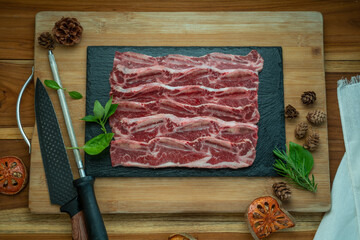 Beef Short Ribs (Sliced) Bone-in on wooden background.Cross Cut Short Ribs beef on black plate. 