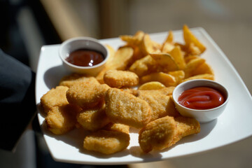 fried chicken nuggets on white plate with sauces 