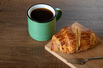 Croissant with a cup of full coffee,directly above	