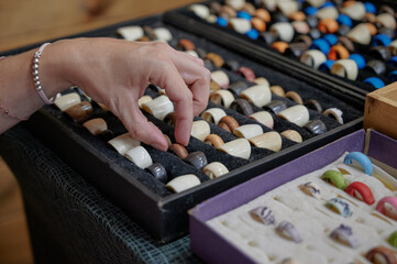 Spanish wooden rings and jewelry made by local artisan, displayed on samplers of a small shop of a flea market to be sell like souvenirs. Hand made items.
