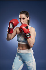 Female boxer training on blue background