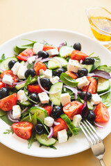 Greek salad of fresh cucumber, tomato, red onion, feta cheese and olives with olive oil. Healthy food, top view