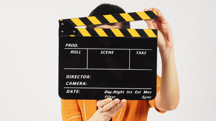 The woman's body part hold a Black and yellow Clapperboard  and she wears a yellow mustard suit on...