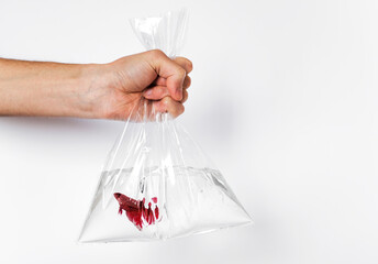 a man holds in his hand a bag of fish in the water for an aquarium
