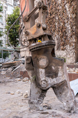 Kyiv (Kiev), Ukraine - July 17, 2021: crusher machine, a huge bucket of an excavator, bulldozer ruin house, demolition