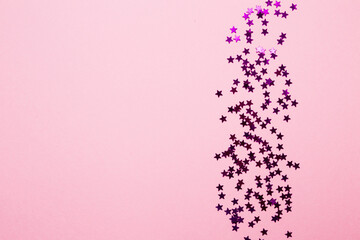 Closeup asterisks sprinkled on a pink isolated background. View from above. - obrazy, fototapety, plakaty