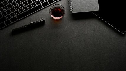 Modern black workspace background with accessories and copy space