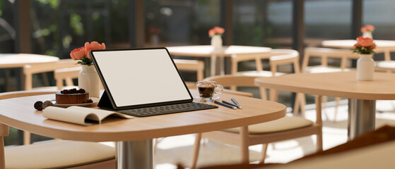 Workspace with portable tablet on wood coffee table in the beautiful co-working space.