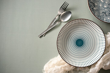 Trendy ceramic porcelain plates with fork and spoon on grey background.