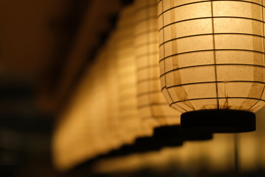close up a row of traditional Japanese paper lanterns in diminishing perspective at night