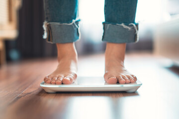 Feet of woman standing on electronic scales for weight control, Female Checking BMI Weight Loss....