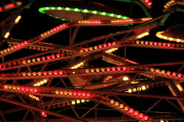 Amusement park with amusement rotating wheel and lights on it.