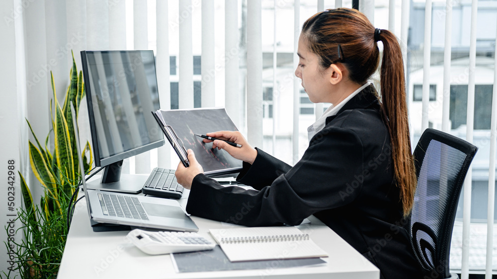 Poster Businesswoman is pointing stock data chart to taking note on document and checking data of stock exchange trading