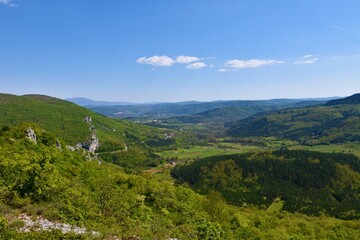 Scenic view of mountains and hills in Istria in Slovenia and a meadow with low growing mediterranean trees near Socerga
