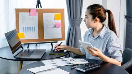 Business woman holding tablet and using digital tablet with laptop for investment planning of new business