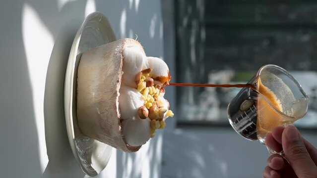 Vertical footage : Pouring coffee on vanilla ice cream to make an affogato coffee