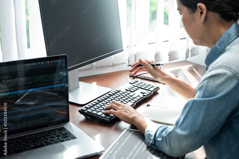 Poster asian woman programmer holding pen and looking on keyboard to typing code data about new project on 